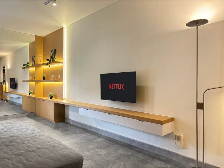 Helsinki: Smart TV dengan Netflix di ruang keluarga, dengan lampu berdiri di sampingnya.