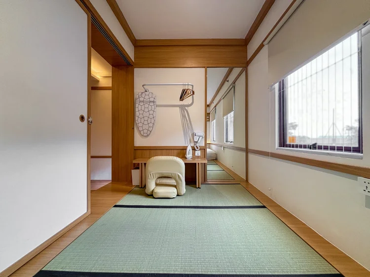 Omotesando: Lantai tatami di kamar, dengan bangku kecil dan gantungan baju di dinding.