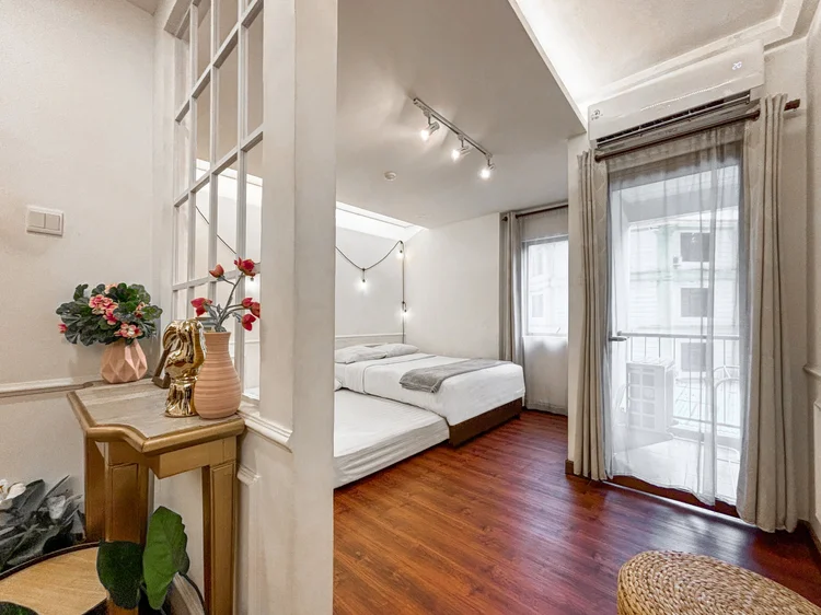 Provence: Area tidur dilihat dari ruang tamu, dengan tirai dan pintu ke balkon kecil.