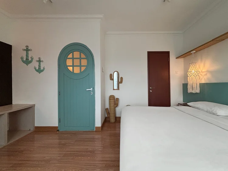 Mykonos: Kamar utama dengan pintu bundar biru, rak, dan cermin, gaya pulau sampai ke kamar.