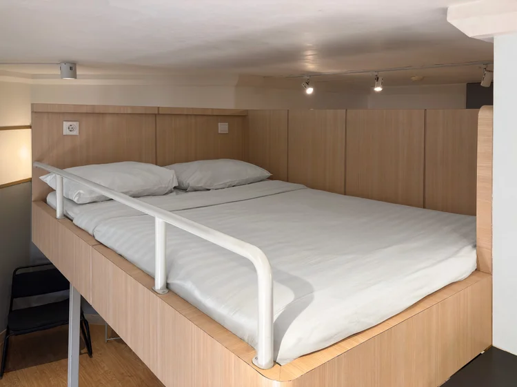 Den Haag: Sprei putih di loft bed, standar yang sama di semua unit kami.