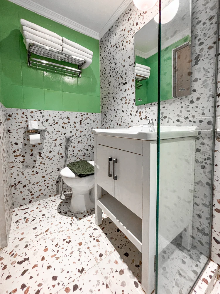Tanzania: Kamar mandi modern dengan toilet dan shower berdinding kaca, dibersihkan tim terlatih kami dengan standar CHSE sebelum tiap check-in.