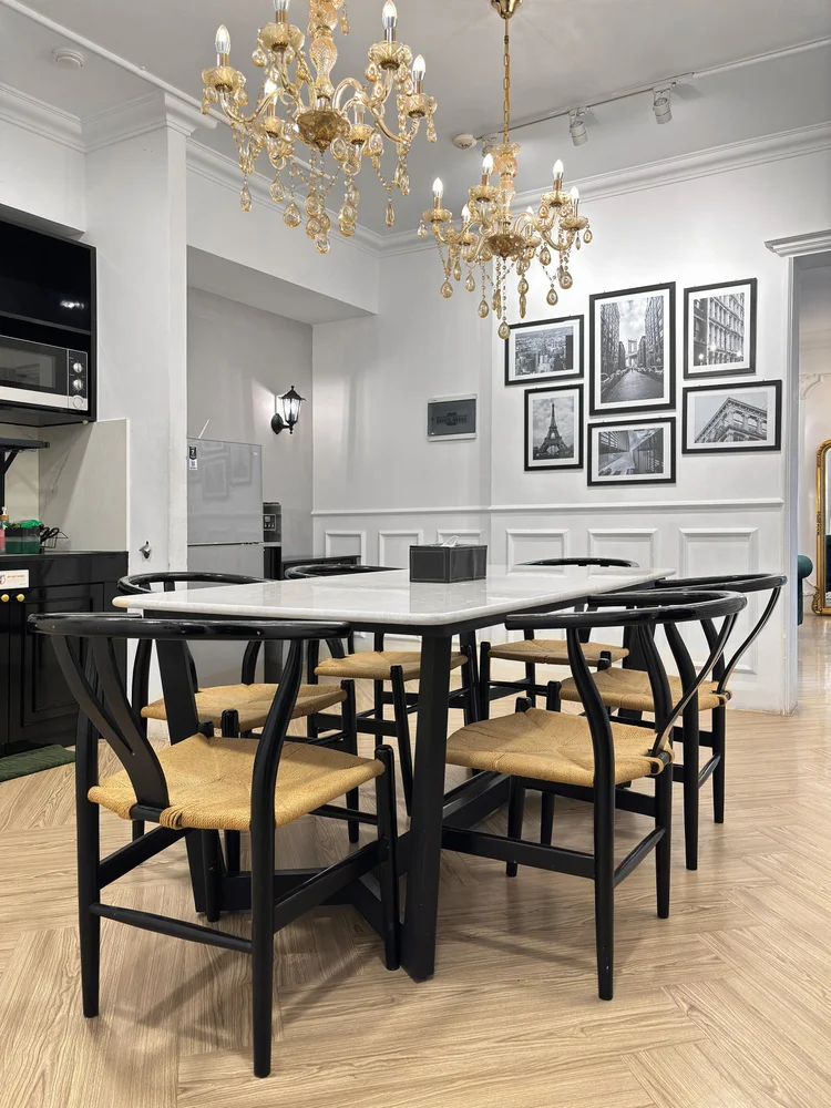 Paris: Meja makan untuk enam orang di bawah lampu kristal, dapur di sampingnya.