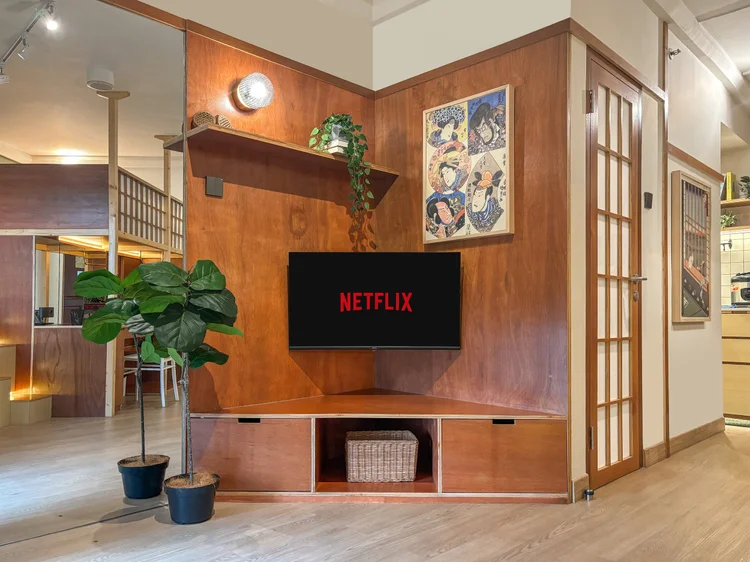 Kanazawa: Dinding kayu dengan smart TV dan Netflix, tangga di sebelahnya naik ke loft.