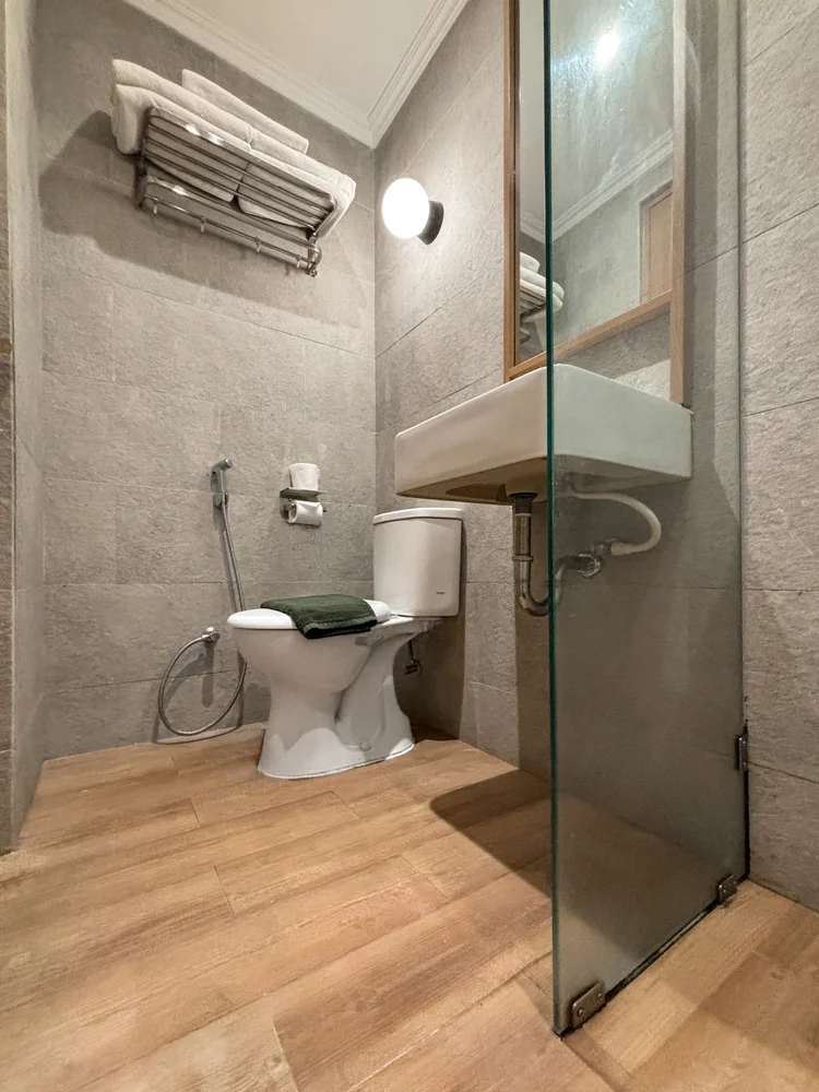 Sapporo: Kamar mandi modern dengan shower berdinding kaca dan toilet.