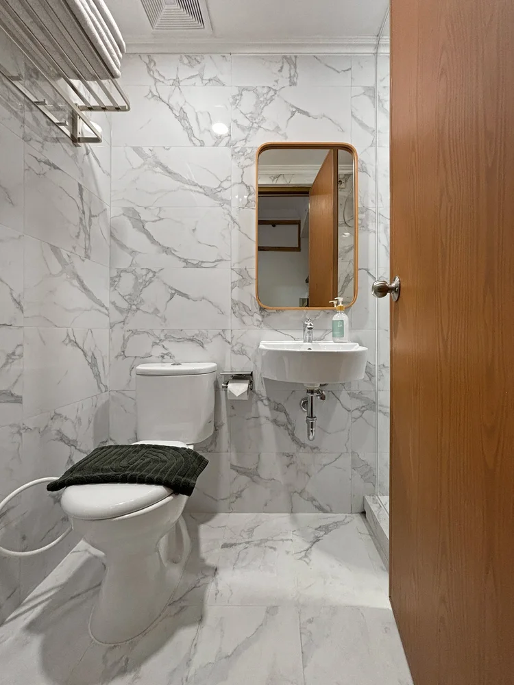 Hokkaido: Kamar mandi modern bernuansa marmer, dengan wastafel dan cermin.