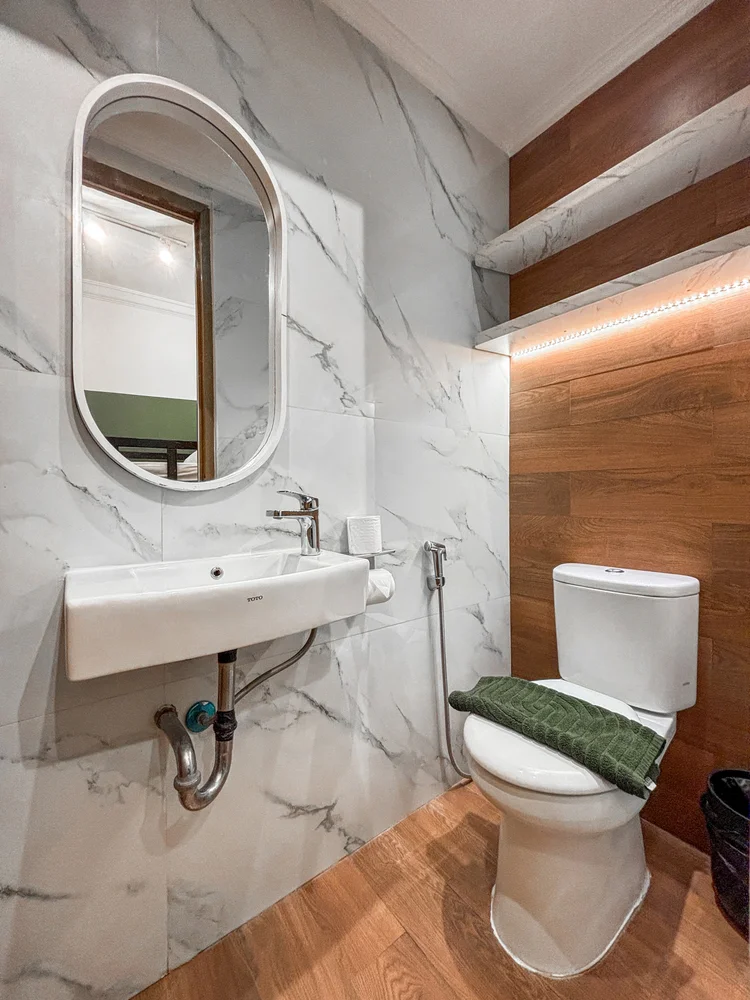 Salzburg: Kamar mandi kecil di kamar ranjang susun: wastafel dan toilet dengan lantai kayu.