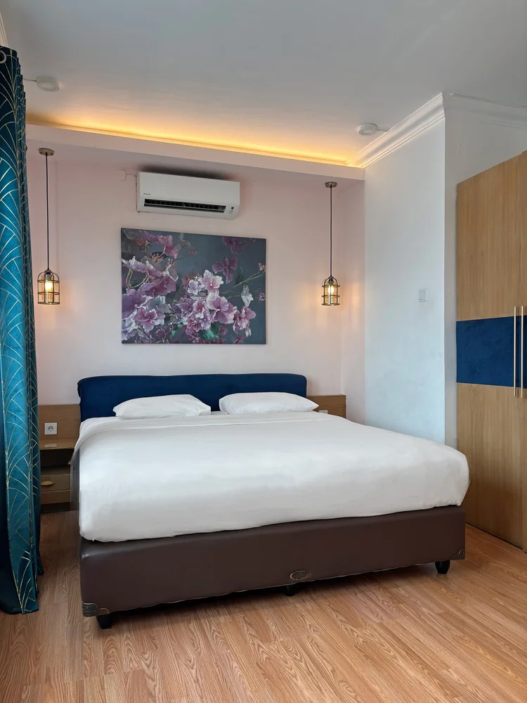 Beverly: Kamar tidur dengan AC sendiri dan lemari, lukisan bunga di atas kepala ranjang.