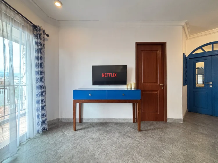 Santorini: Smart TV dengan Netflix di ruang keluarga, pintu ke balkon dengan pemandangan kota dan pegunungan.