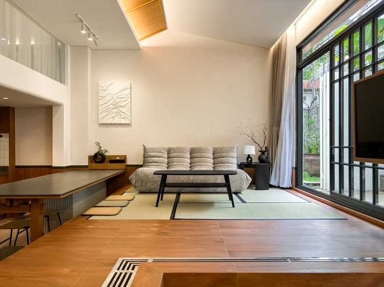 Shizuoka: Ruang keluarga loft: sofa di atas tatami, pintu kaca ke patio luar.