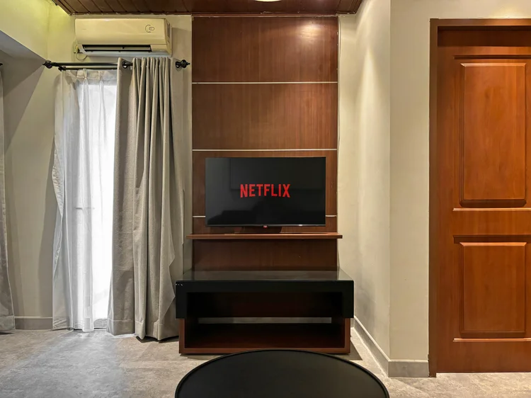 Saitama: Smart TV dengan Netflix di rak kayu, AC di ruang keluarga.