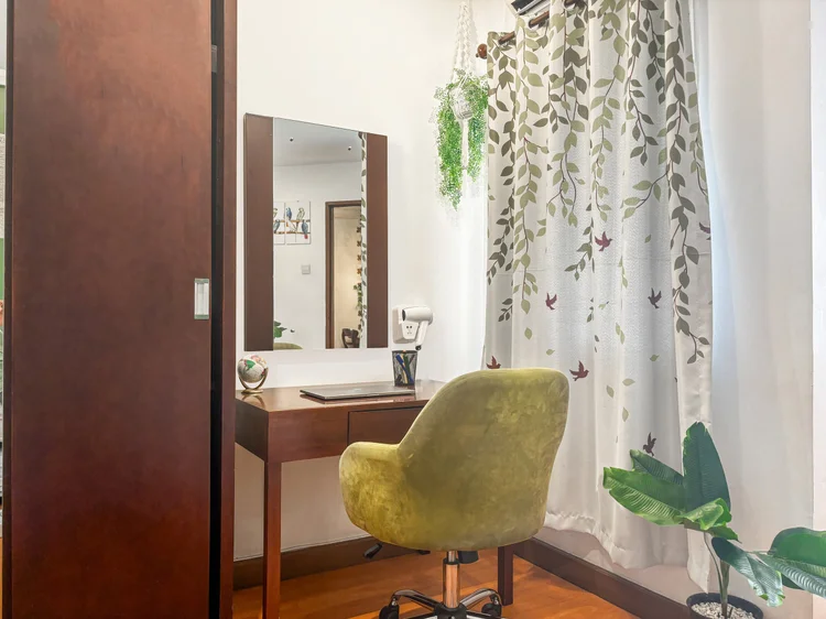 Tanzania: Meja rias dan lemari geser di kamar utama, dengan tirai motif dedaunan di jendela.