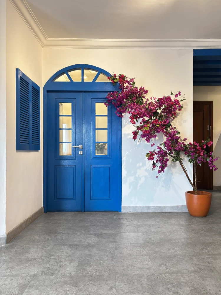 Santorini: Pintu biru dan bunga bugenvil di pintu masuk, sesuai tema Island Dream.