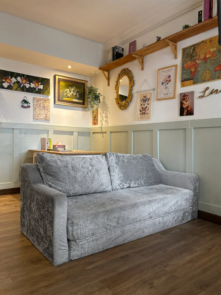Florence: Sofa empuk di ruang keluarga, menghadap dekorasi dinding ala Prancis.