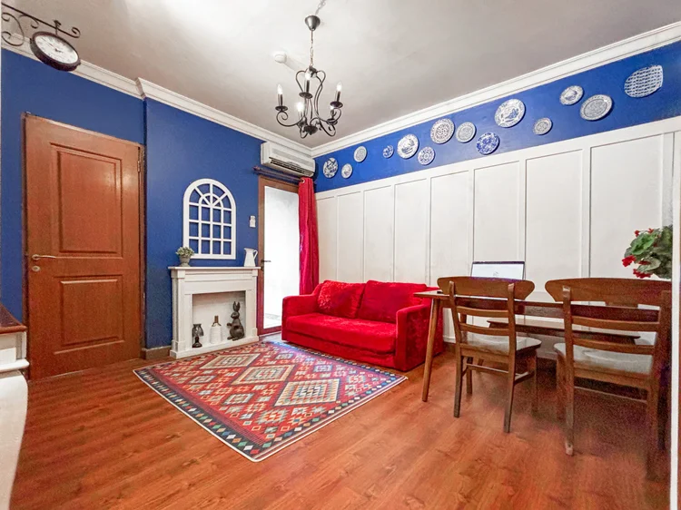 Amsterdam: Ruang keluarga dengan sofa merah, meja makan, dan AC sendiri, tempat semua orang kumpul.
