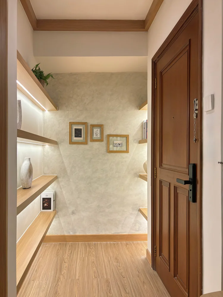 Nara: Lorong masuk dengan rak dan bingkai kecil, pintu utama di ujungnya.