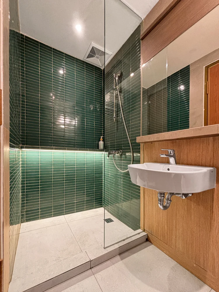 Aoyama: Kamar mandi modern dengan keramik hijau dan shower air hangat.