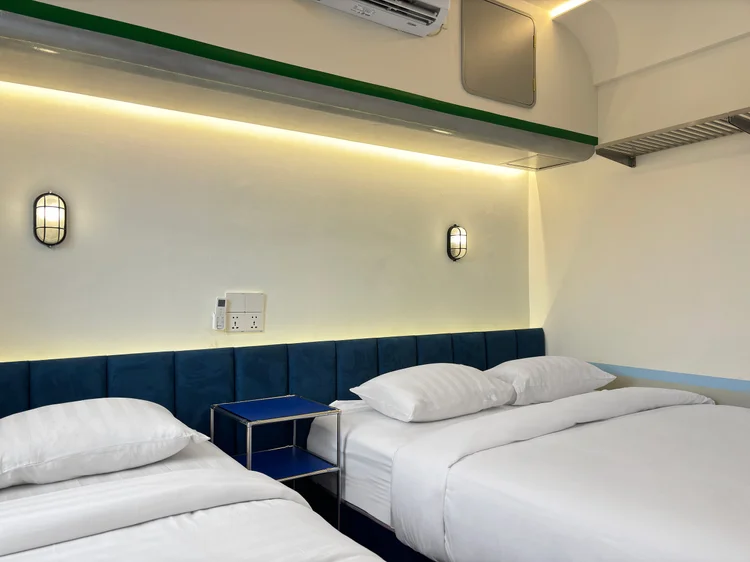 Dae Jeon: Kamar dengan queen bed dan single bed, sprei putih standar yang sama di semua unit kami.
