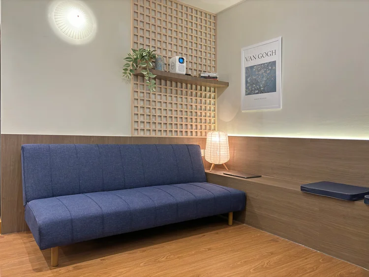 Aoyama: Sofa bed dan bangku panjang di depan layar; sofanya sudah termasuk kapasitas 5 orang.
