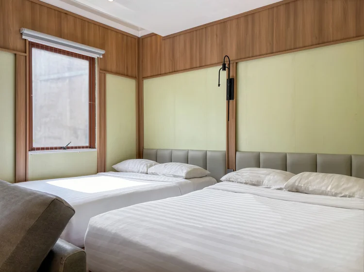 Sapporo: Dua small double bed ala Jepang berdampingan di panggung, dengan AC di area tidur.