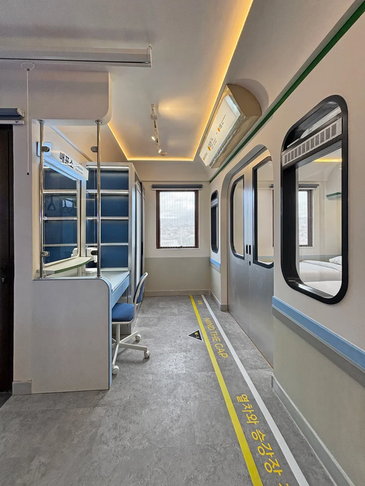 Dae Jeon: Lorong dengan rak dan cermin, menghubungkan kamar dan ruang depan.