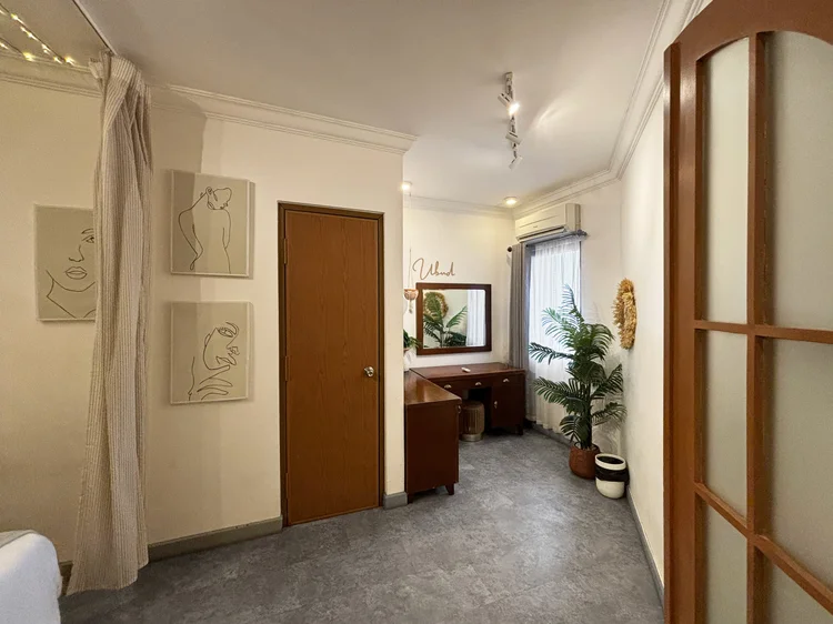 Ubud: Koridor menuju kamar-kamar, dengan lukisan garis minimalis dan tanaman di sepanjang jalan.