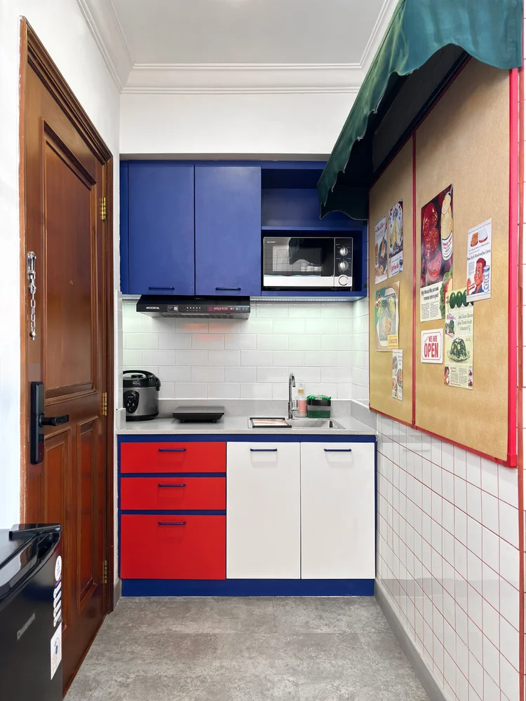 Miami: Dapur terbuka berkabinet biru dan merah, dengan microwave dan kompor induksi.
