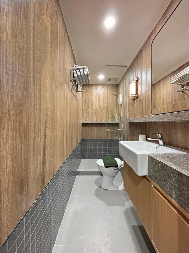 Kawaguchi: Kamar mandi modern berdinding motif kayu; sabun dan sampo sama di semua unit.