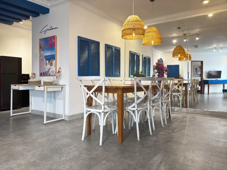 Santorini: Meja makan panjang untuk delapan orang, dengan jendela berdaun biru ala Santorini.