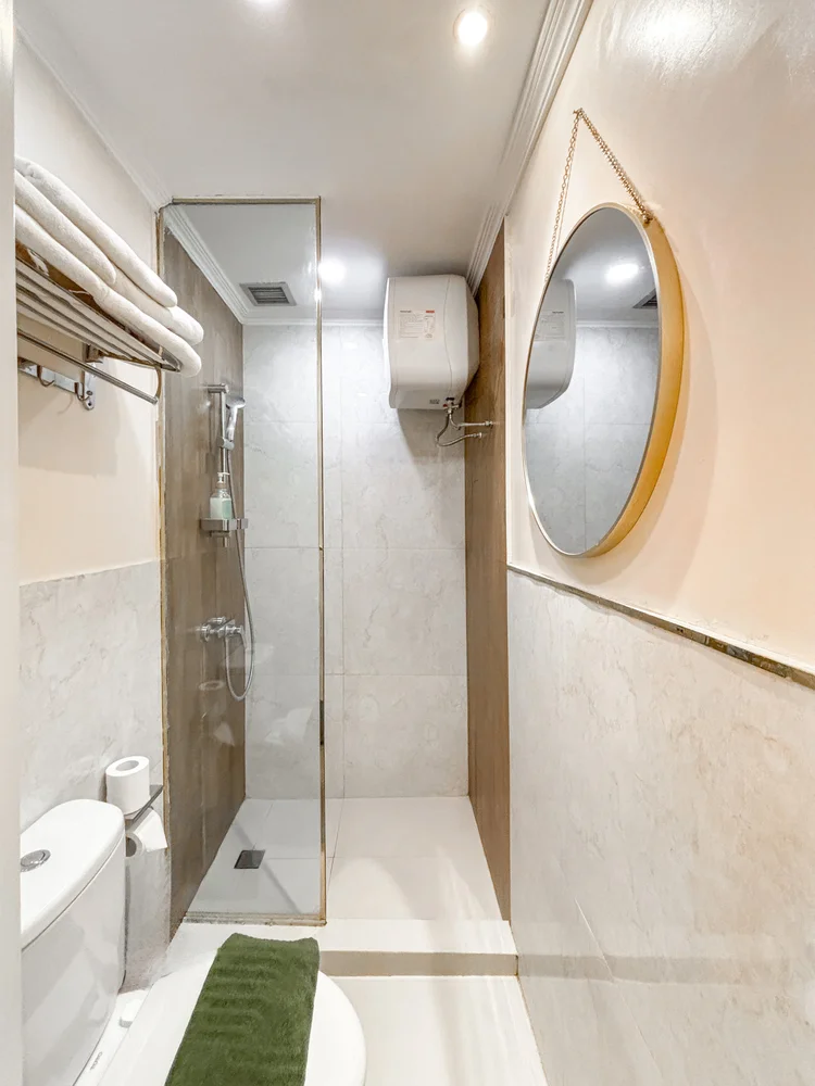 Provence: Kamar mandi dengan shower air panas dan cermin bulat berbingkai emas.