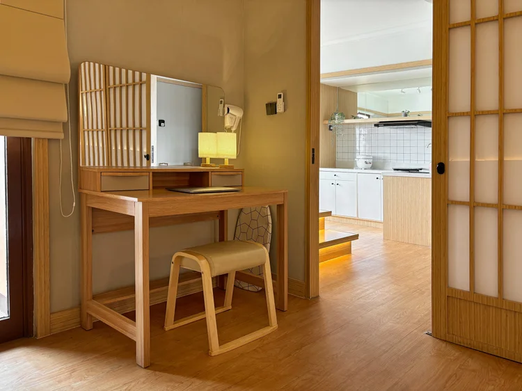 Fukuoka: Meja rias kayu dengan bangku di kamar, dapur terlihat di seberangnya.