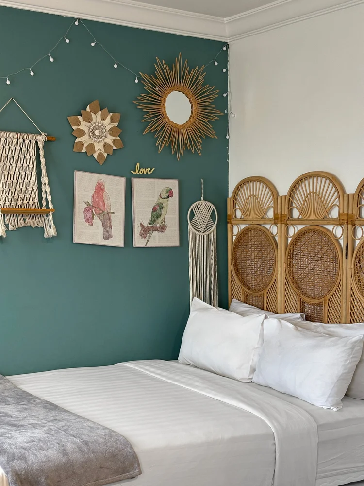 Florence: Kamar kedua bertema teal, dengan hiasan rotan dan macrame di dinding.