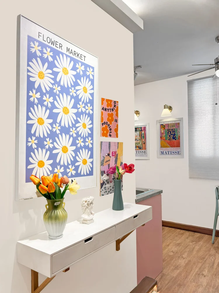 Milan: Rak konsol dengan bunga dan poster Flower Market, warna pastel khas Milan.