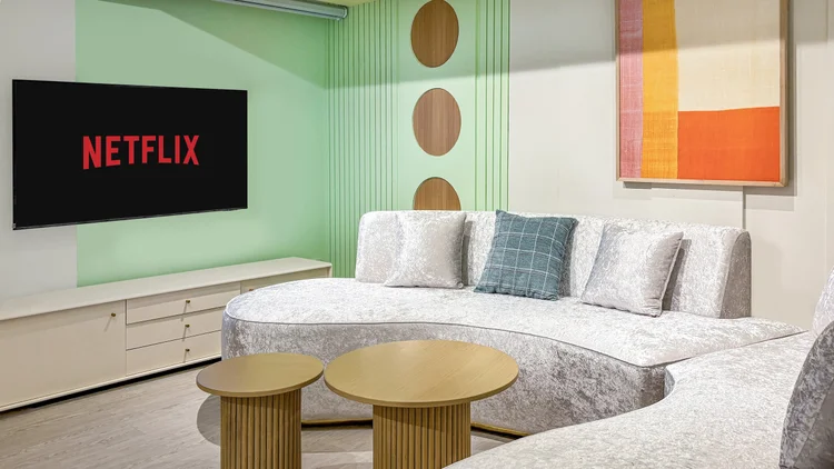 Gangnam: Sofa besar menghadap smart TV 55 inci dengan Netflix, cukup buat nonton bareng.