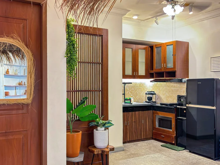 Ubud: Dapur besar dan terbuka, dengan rak kayu berlubang dan kulkas dua pintu.