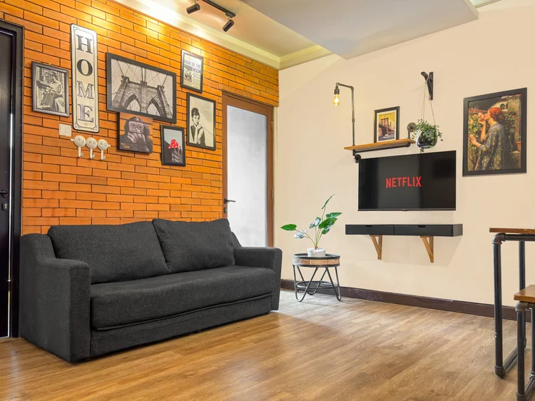 Brooklyn: Tema Instagramable Urban: bata ekspos, bingkai hitam, dan TV dengan Netflix.