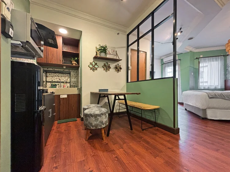 Panama: Meja makan untuk berempat dengan bangku dan stool, area tidur di balik partisi kaca.