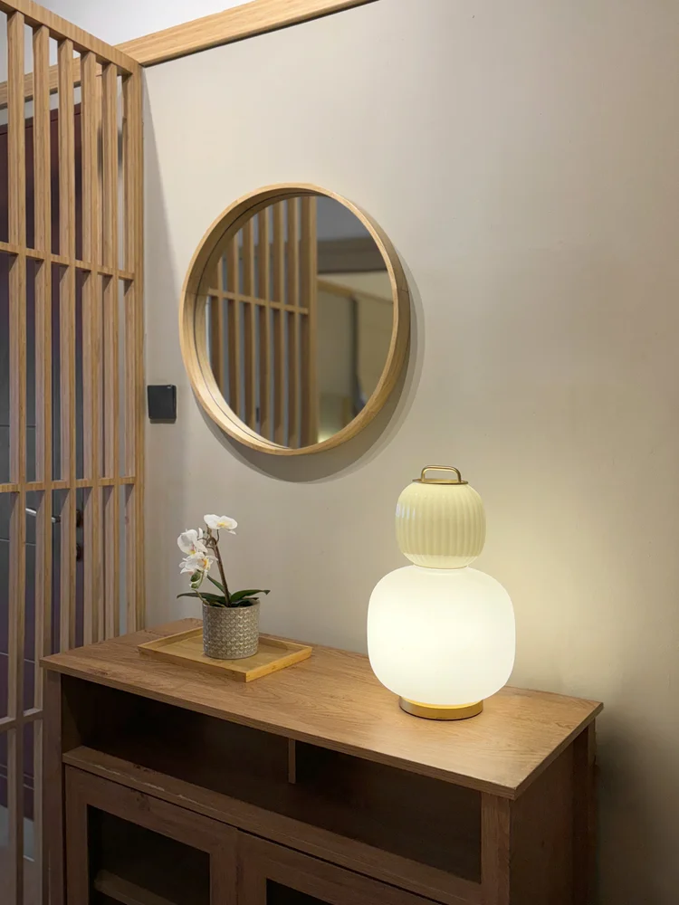 Fukuoka: Cermin bulat dan lampu meja di konsol pintu masuk, sentuhan Jepang yang tenang.