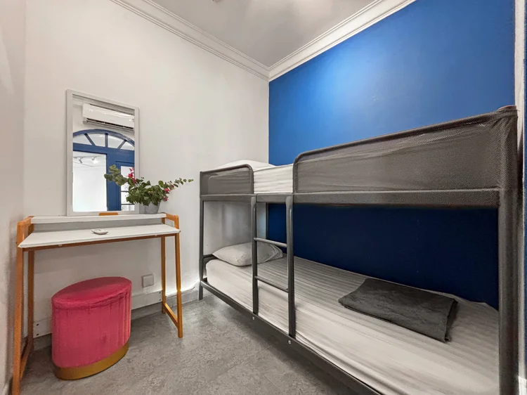 Santorini: Kamar dengan ranjang susun, meja rias, dan dinding biru laut.