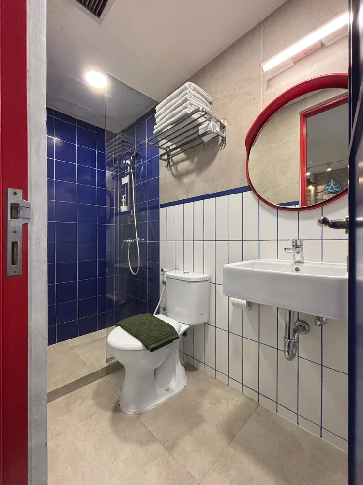 Shibuya: Kamar mandi modern dengan shower air panas dan ubin biru.