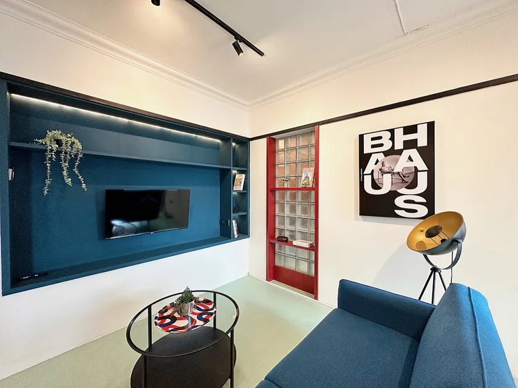 Berlin: Ruang keluarga dengan warna khas Bauhaus, sofa menghadap smart TV.