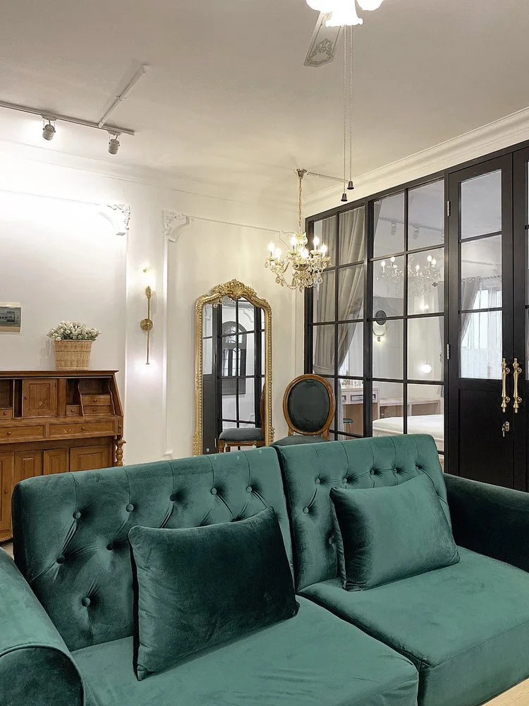 Paris: Sofa beludru hijau dengan bantal, kipas langit-langit di atasnya.