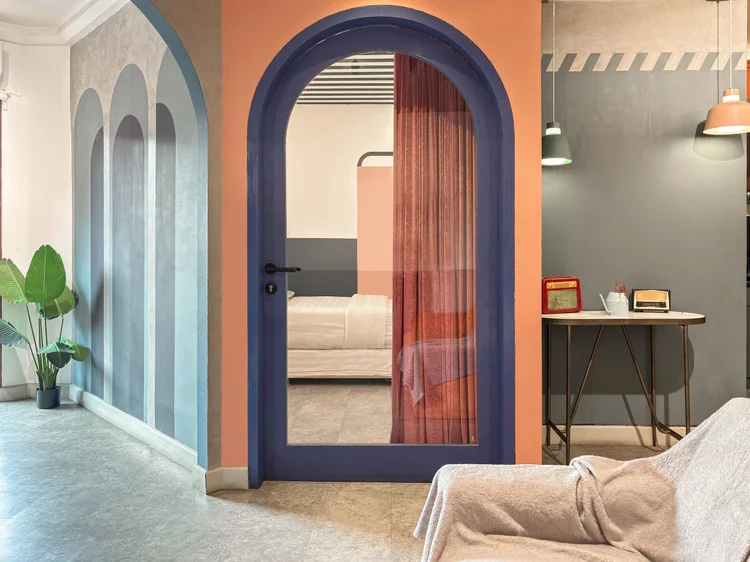 Geneva: Lengkung bertirai menuju kamar tidur, dengan tanaman di sudut.