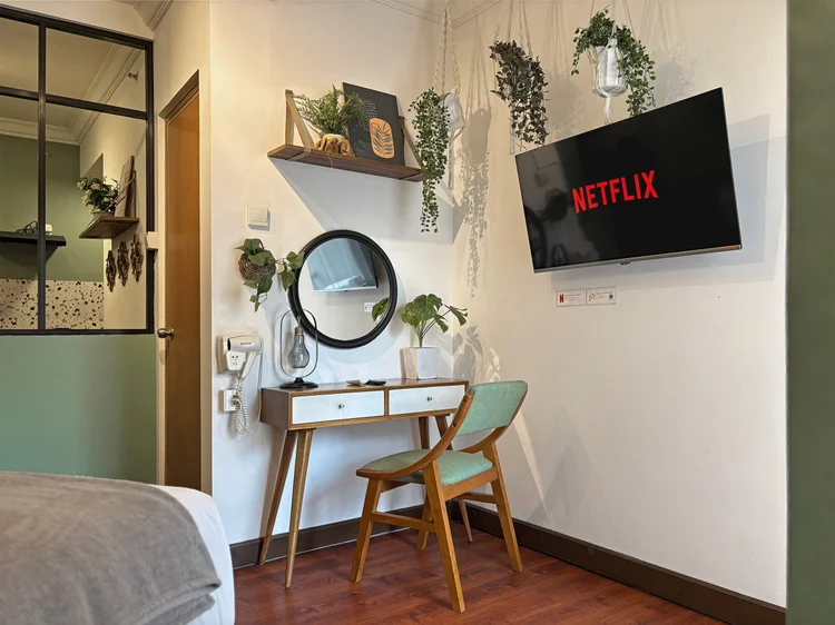 Panama: Meja rias dengan cermin bulat, TV dengan Netflix menghadap ke kasur.