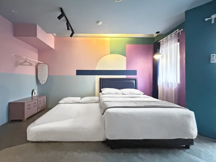 Montreal: Area tidur dengan dinding blok warna, AC, dan small double bed 140 cm.