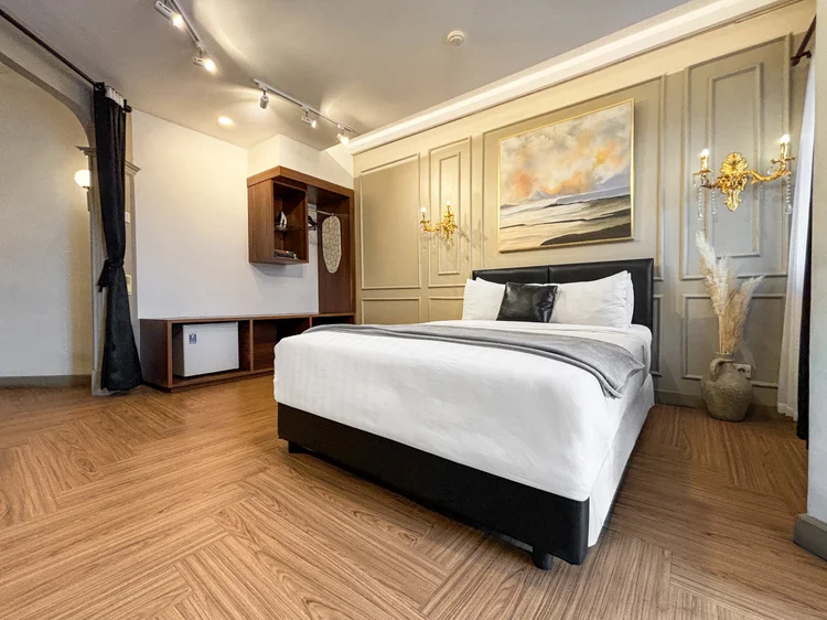 Vienna: Area tidur bertema Classical: kasur, sconce emas, dan lukisan langit di atas kepala tempat tidur.
