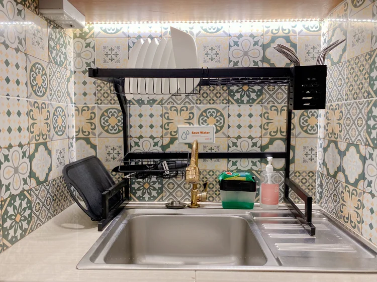 Saigon: Wastafel dapur dengan ubin motif Peranakan dan rak pengering piring.