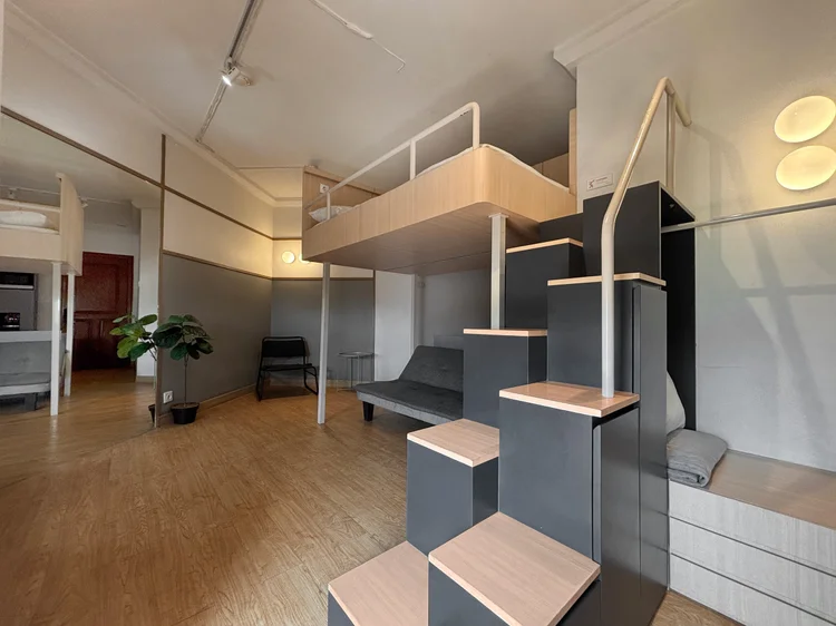 Den Haag: Tangga dan pagar pengaman loft bed, dengan AC dan tanaman di sudut.