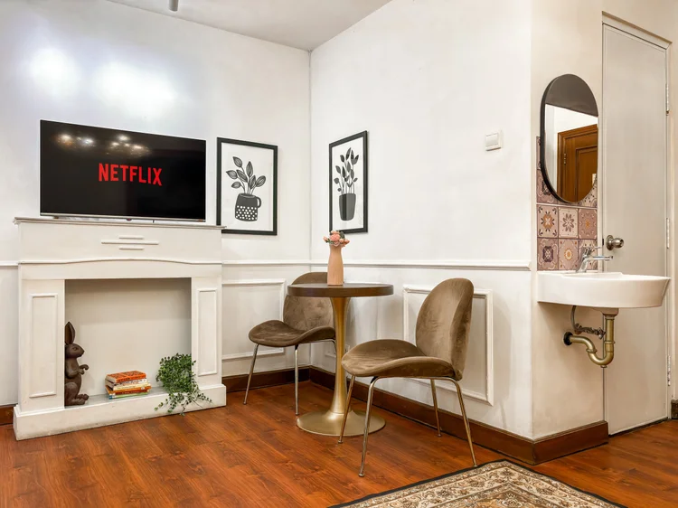 Provence: TV dengan Netflix di atas perapian hias, meja makan untuk berdua di sampingnya.