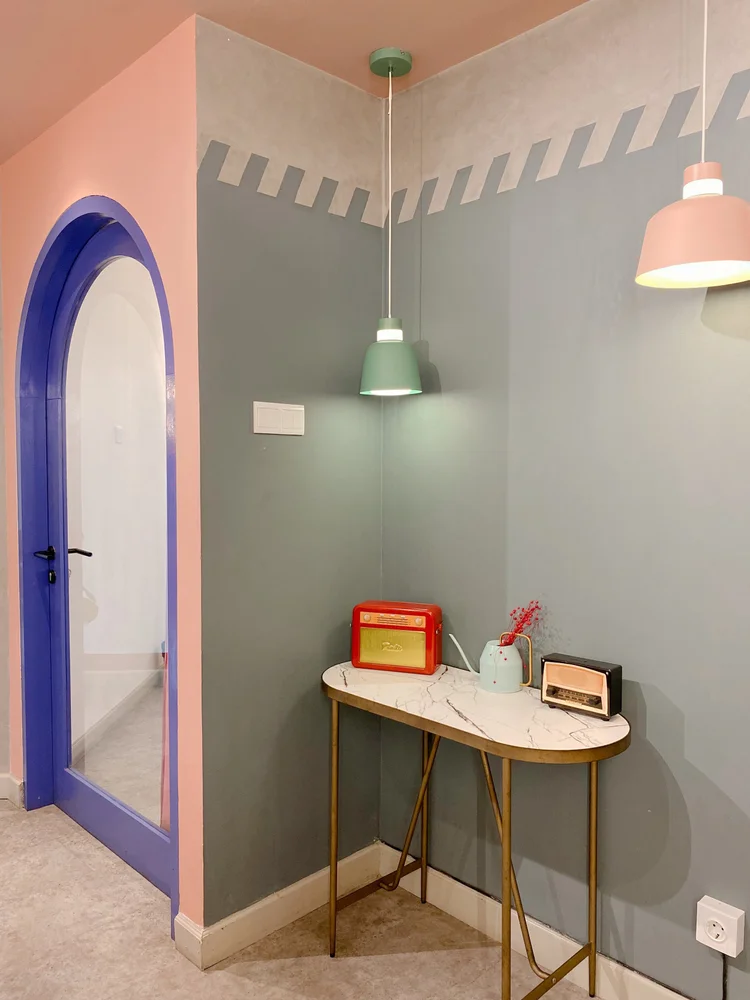Geneva: Meja kecil dengan radio vintage, di bawah lengkung ungu dan lampu gantung.